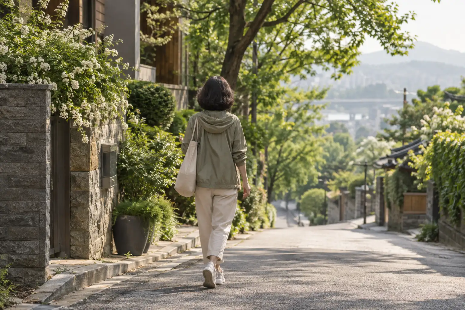 아침 햇살 속에서 걷는 여성의 뒷모습